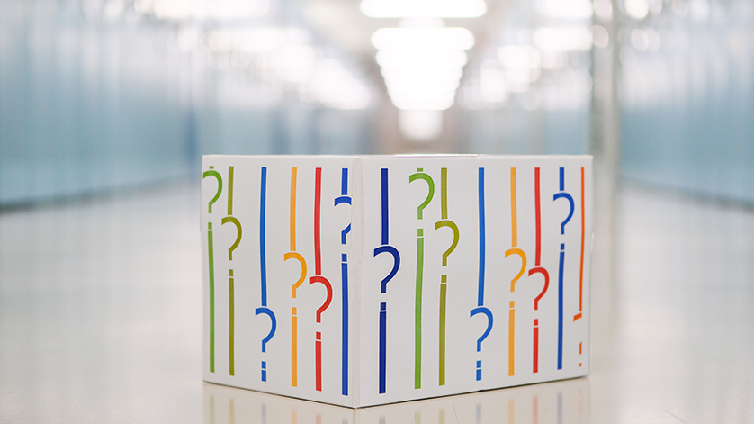 Kiste mit Fragezeichen in den Farben des Logos der Deutschen Nationalbibliothek 