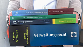 A person carrying several books on the topic of administration