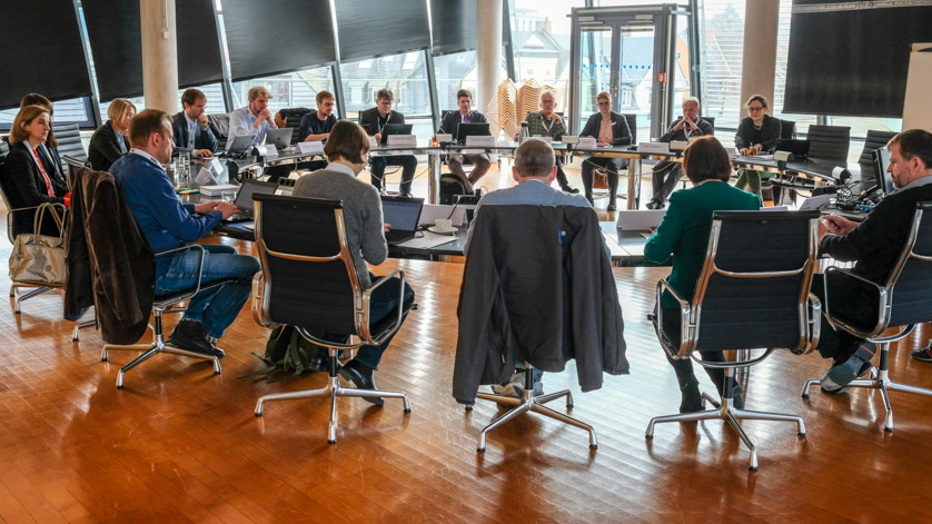 24 Teilnehmerinnen und Teilnehmer eines Workshops sitzen am großen runden Tisch im Sitzungssaal der Generaldirektion in Frankfurt am Main