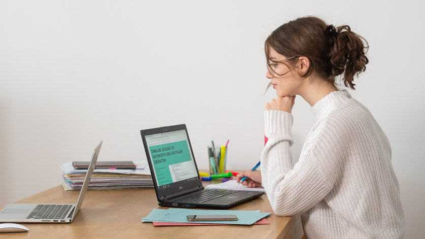 Eine junge Frau sitzt vor ihrem Laptop, auf dem die Webseite „DNB LAB“ geöffnet ist.