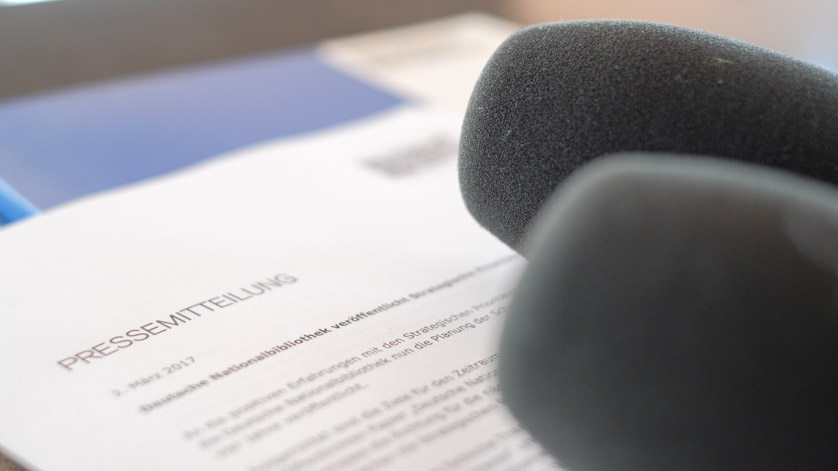 Pressemappe, Pressemitteilung und Mikrofone für eine Pressekonferenz Pressemappe, Pressemitteilung und Mikrofone für eine Pressekonferenz