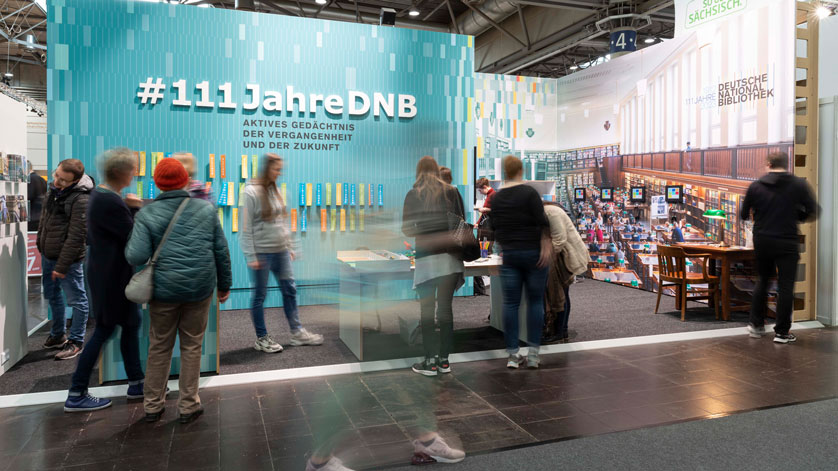 Aktionsfläche der Deutschen Nationalbibliothek auf der Leipziger Buchmesse. Im Hintergrund ist der Hashtag #111JahreDNB zu lesen.