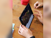 Zwei Hände halten und verwenden ein Tablet, auf dem ein Bild im Bearbeitungsmodus zu sehen ist. Zwei Hände halten und verwenden ein Tablet, auf dem ein Bild im Bearbeitungsmodus zu sehen ist.