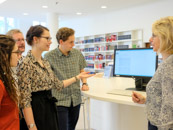 Eine Gruppe Benutzer*innen steht bei einer Benutzungseinführung im Lesesaal um einen Katalogbildschirm herum Eine Gruppe Benutzer*innen steht bei einer Benutzungseinführung im Lesesaal um einen Katalogbildschirm herum