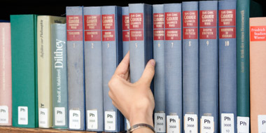 Schonend wird ein Buch an seinen beiden Buchdeckeln aus dem Regal gezogen und nicht am oberen Schnitt. Die links und rechts danebenstehenden Bücher werden dazu etwas nach hinten geschoben. Schonend wird ein Buch an seinen beiden Buchdeckeln aus dem Regal gezogen und nicht am oberen Schnitt. Die links und rechts danebenstehenden Bücher werden dazu etwas nach hinten geschoben.