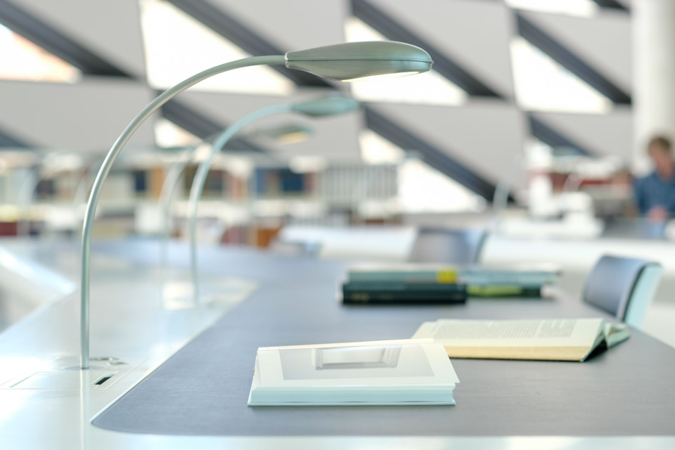 Arbeitsplatz im Museumslesesaal mit Leselampe; auf dem Tisch liegen zwei aufgeschlagene Bücher Arbeitsplatz im Museumslesesaal mit Leselampe; auf dem Tisch liegen zwei aufgeschlagene Bücher