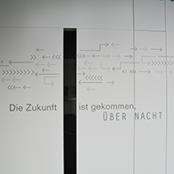 „Die Zukunft ist gekommen, über Nacht“, Seitenansicht mit Spruch an der KI-Box  „Die Zukunft ist gekommen, über Nacht“, Seitenansicht mit Spruch an der KI-Box