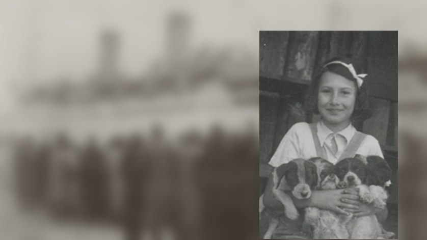 Die Schwarzweißfotografie zeigt Stefanie Zweig im Porträt, auf ihrem Schoß hält sie vier Hundewelpen.