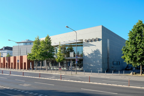 Kongresszentrum der Deutschen Nationalbibliothek an der Frankfurter Adickesallee. Betonkubus mit Glasfront und Bäumen, seitlich die mäandernde Backsteinmauer von Per Kirkeby