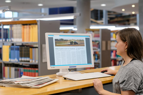 In the reading room of the German National Library, a user reads the e-paper edition of a daily newspaper on her computer screen. There are some printed editions of newspapers on the table. In the reading room of the German National Library, a user reads the e-paper edition of a daily newspaper on her computer screen. There are some printed editions of newspapers on the table.