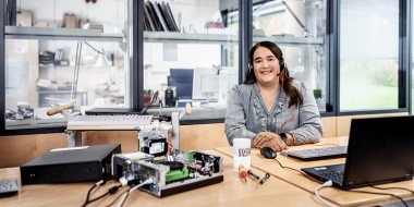 One employee is sitting at her desk in front of a laptop. To the left, a dismantled PC. One employee is sitting at her desk in front of a laptop. To the left, a dismantled PC.