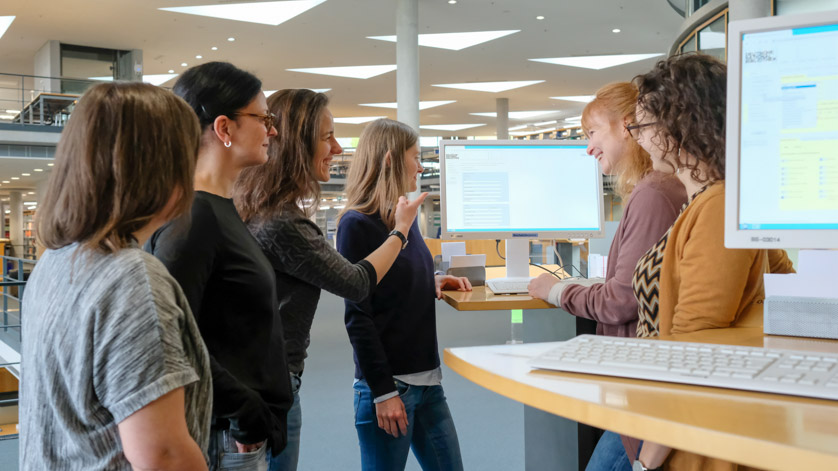 Group of users standing around a catalogue screen during a user introduction in the reading room Group of users standing around a catalogue screen during a user introduction in the reading room