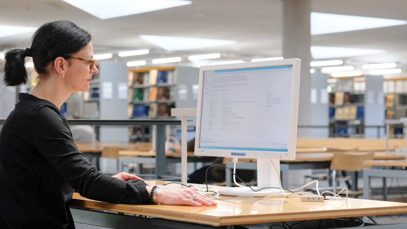 In the reading room of the German National Library, a user researches the catalogue In the reading room of the German National Library, a user researches the catalogue