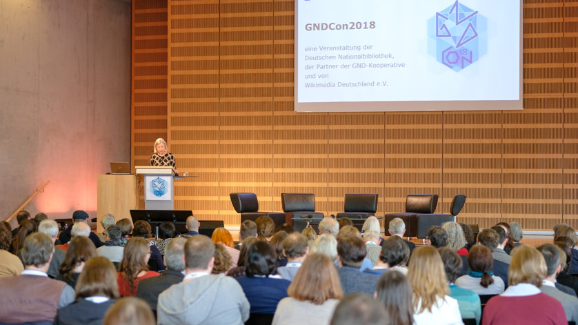 Opening event at GNDCon, the Integrated Authority File Convention held in 2018; Dr. Elisabeth Niggemann greets participants Opening event at GNDCon, the Integrated Authority File Convention held in 2018; Dr. Elisabeth Niggemann greets participants