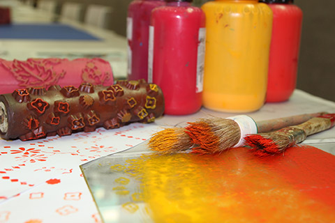 Brushes, wallpaper sample and bottles of red and yellow ink Brushes, wallpaper sample and bottles of red and yellow ink