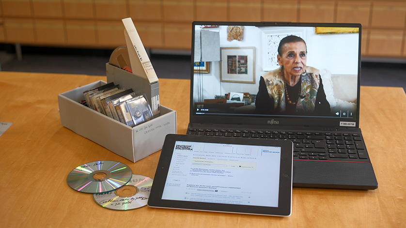 CDs, music cassettes, tapes, a tablet and an open laptop lie on a table. CDs, music cassettes, tapes, a tablet and an open laptop lie on a table.