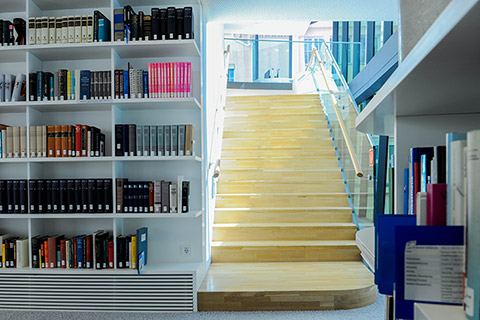 Reference collection and stairs on the lower floor of the music reading room 